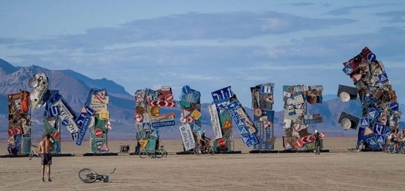 An installation built by Ukrainians at Burning Man, giant letters assembled from road signs in the desert