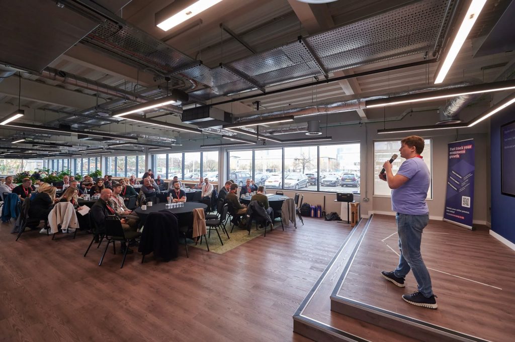 Paul Ryazanov presenting to a large audience at an ecommerce event