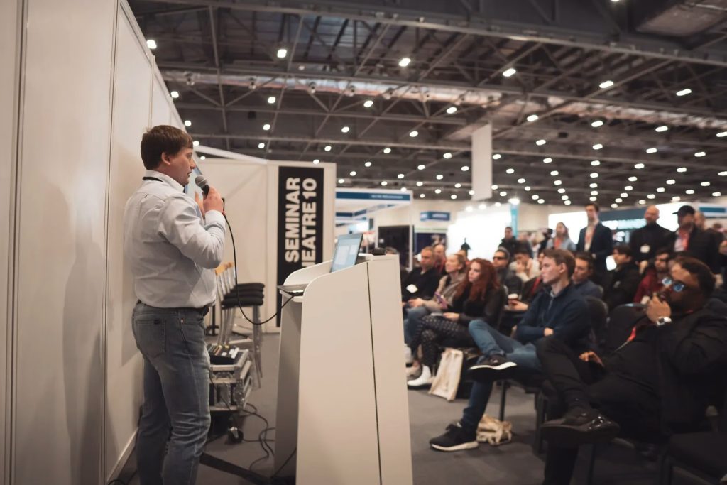 Paul Ryazanov speaking in a seminar theatre at an international trade exhibition