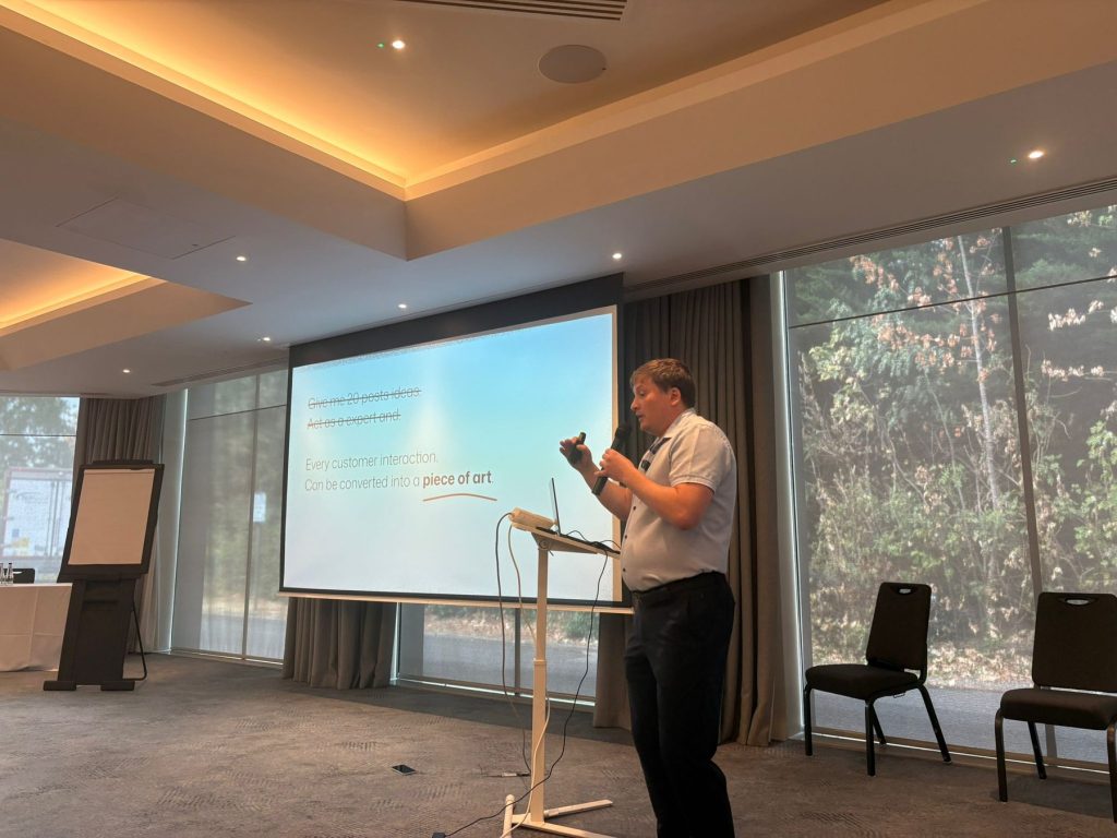Paul Ryazanov presenting at the UK SEO Summit 2026, slide reading Every customer interaction can be converted into a piece of art